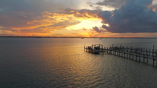 Aerial Sunset Over Stuart, Florida Waterfront Docks and Palm Trees With Golden Reflection