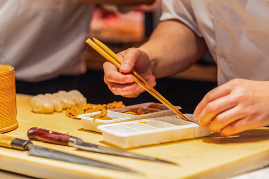 Sushi chef preparing fresh ingredients with precision and skillful hands