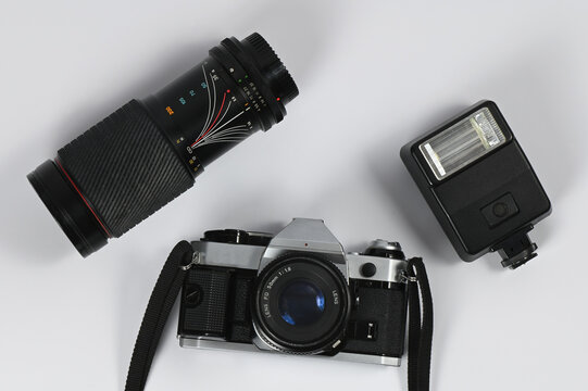 An old analog film camera with a flash and a macro lens on a white background