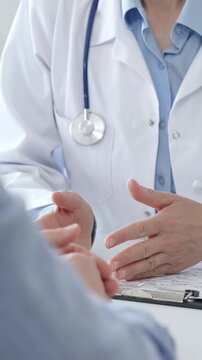 Female doctor explaining diagnosis to her patient during a medical consultation in a bright medical office, healthcare and medical concept. Medicine and health care concept