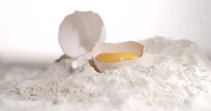Egg drops into flour in slow motion detail