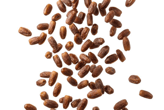 Falling dried dates scattered on black background