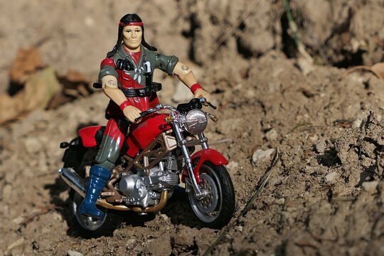 GI JOE action figure of native american infantryman and tracker Spirit aka Charlie Iron-knife, model from year 1984, riding on rough arid soil with Ducati Monster 900 naked motorbike. 