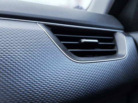 Closeup view of modern car dashboard air vent featuring textured black surface sleek chrome trim horizontal ventilation slats automotive interior detail climate control component passenger cabin conte