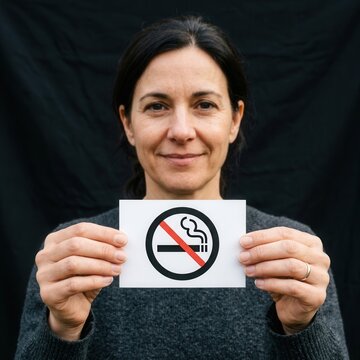 Woman Holds No Smoking Sign Against Dark Background Promoting Healthy Lifestyles