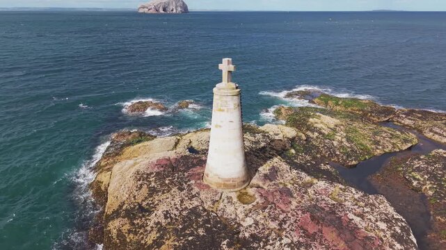 Detailed close up aerial view of St Baldreds Cross monument on rocky outcrop in Scotland