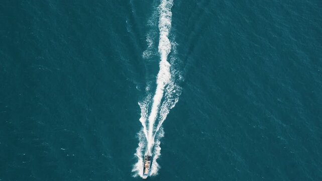 Top down aerial view of speedboat moving fast across blue tropical sea near Phu Quoc Island, Vietnam. Water sports, marine adventure, summer vacation, island tourism, active lifestyle, tropical travel
