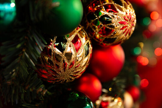 Boules de No&euml;l rouges, vertes et dor&eacute;es en gros plan avec bokeh dans une ambiance festive, fond de No&euml;l