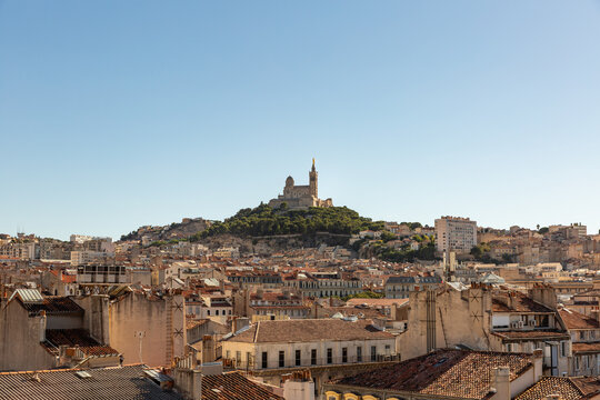 Vue panoramique sur les toits de la ville de Marseille avec la Basilique Notre-Dame de la Garde au centre de l'image sur fond de ciel bleu