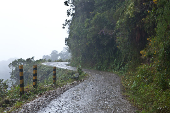Wet and narrow Yungas Death Road in Bolivia mountain rainforest
