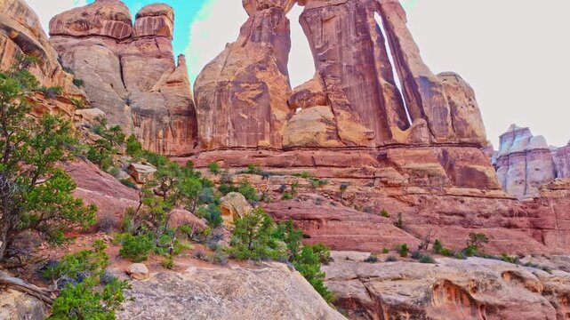 Vast panoramic vista reveals the monumental sandstone form of Druid Arch rising among rugged spires in Canyonlands National Park Utah