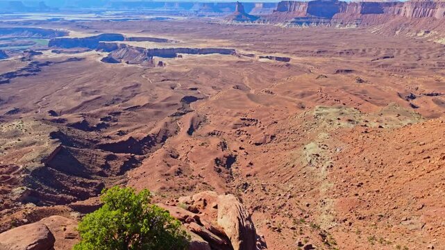 Warm evening light sweeps across deep canyons and river valleys along the Murphy Point trail in Canyonlands Utah