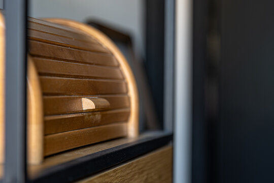 Wooden bread box with roll-top door. Kitchen storage detail with warm wood grain.