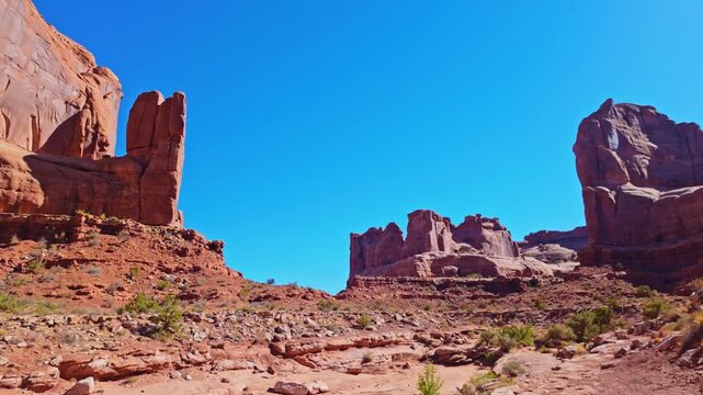 Warm sunset light illuminates towering Entrada Sandstone monoliths and canyon walls along the Park Avenue trail in Utah