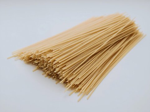 Close up of uncooked spaghetti pasta showing long thin yellow noodles with natural texture