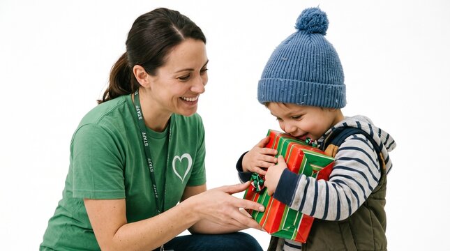 Smiling woman in staff shirt gives a Christmas gift to a happy young boy