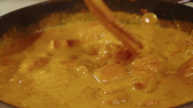 Chicken tikka masala curry boiling in a pan at a professional restaurant kitchen, Indian and Japanese style spicy curry sauce simmering and preparation by a chef