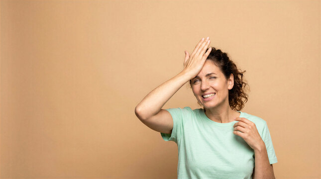 Woman slapping forehead in realization or regret with a smile
