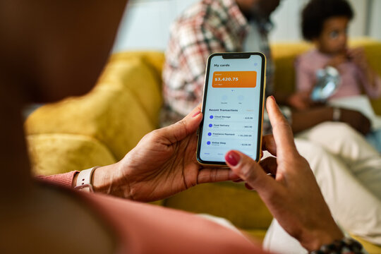 Person checking mobile banking app on smartphone at home