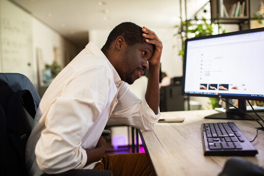 Young man with stomach pain at office desk