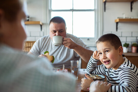 Father and son eating breakfast in home kitchen