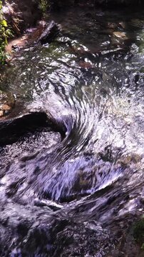 Zoom In on Fast Flowing River Water Rushing over Rocks and Boulders