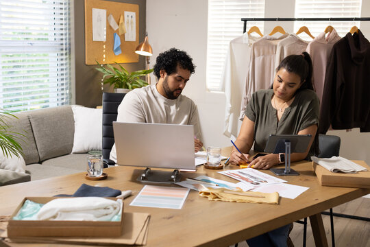 African American colleagues sketching fashion at home studio using wooden table