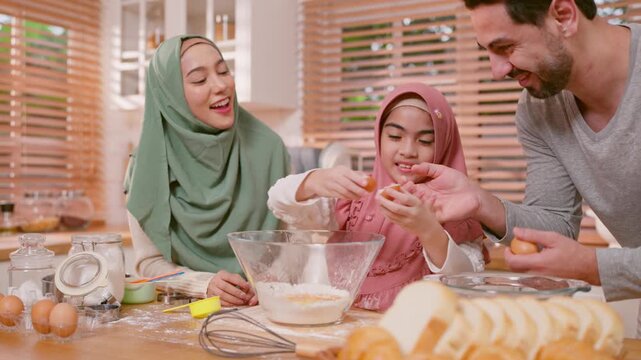 Happy Muslim family baking bakery together in kitchen at cozy home.