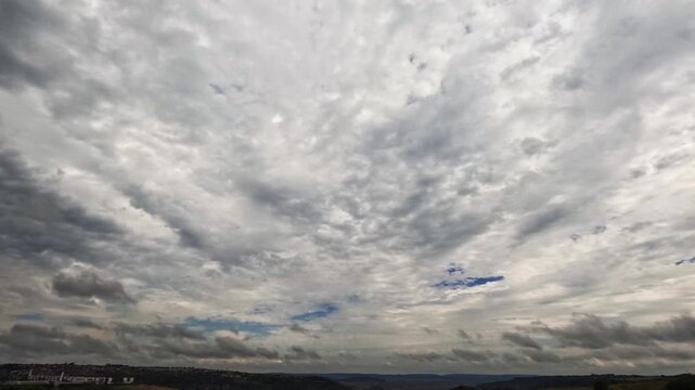 A captivating timelapse footage showing the dynamic and powerful movement of dark, grey storm clouds as they sweep across the sky. This strong visual captures the constant motion of the atmosphere,