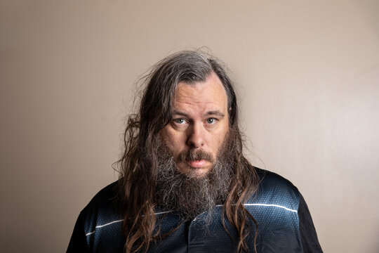 Portrait of a man with long, wavy hair and full beard