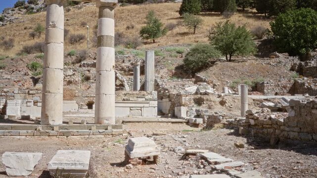 Ephesus ancient ruins defocused background outdoor showing stone columns, toppled blocks and terraced hillside in soft shallow focus; background backplate copyspace calm.