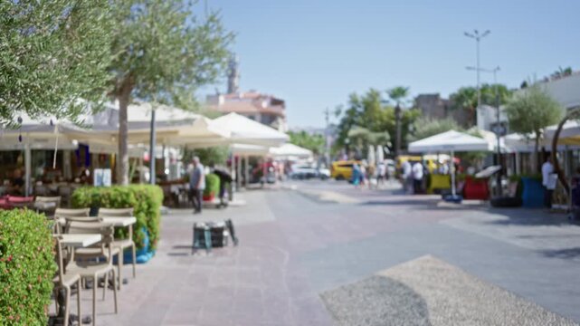 Mediterranean town street scene in soft bokeh and blurred focus background street; background backplate copyspace calm.