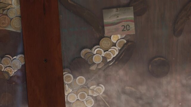 Mexican coins and 20 peso banknote on a weathered surface
