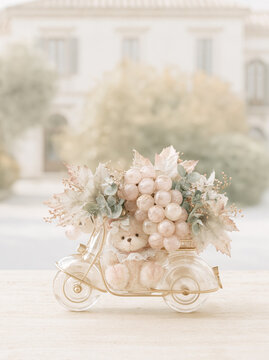 Cute teddy bear on scooter with grapes and autumn leaves.
