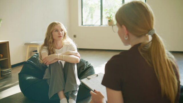 A distressed woman sits in therapy, tearfully sharing her feelings, while the psychologist responds with advice and reassurance.