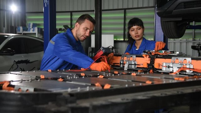 EV technicians inspect engineer inspecting electric vehicle battery
