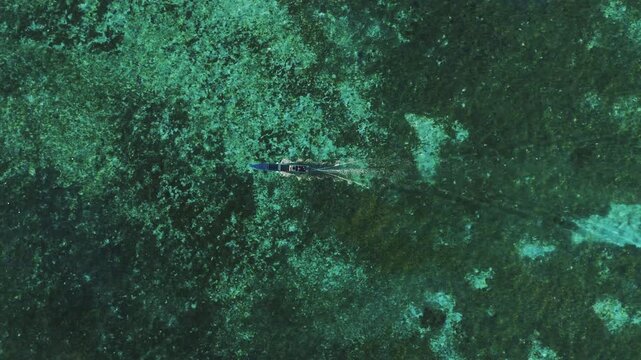 Spectacular drone flyover above Mansuar Island in Raja Ampat during dramatic sunset &ndash; Amazing tropical island landscape with palm trees, sandy shoreline, coral reef and warm sunset light 4k UHD asset