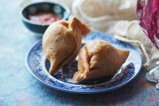 Freshly cooked singara on a blue plate with sauce
