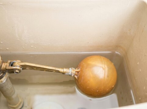 A water tank interior showing a float valve arm and round ball...