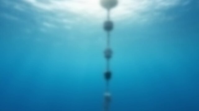 Underwater view of a sensor chain hanging in sunlit blue water, Full Gaussian Blur Abstract