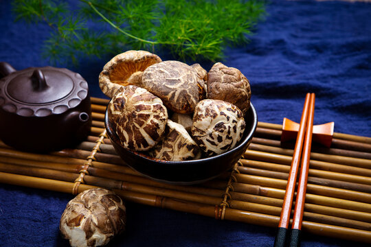 Dried shiitake mushroom on blue printed cloth with teapot