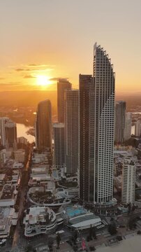 Sunset flaring between the Surfers Paradise towers, aerial drone footage, Gold Coast, Queensland Australia - vertical video