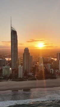 The Q1 tower catching the last light of day, aerial view over Surfers Paradise, Gold Coast, Queensland Australia - vertical video