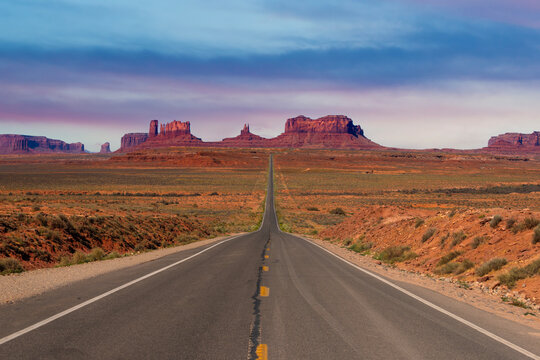 Iconic Scene. Monument Valley Butte Silhouette at Sunrise with Desert Mist and Vibrant Dawn Sky, Arizona, Utah, USA