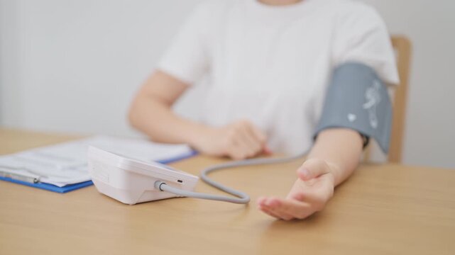 woman checking Blood pressure by Blood pressure monitor with Cuff. Systolic, SYS, Diastolic, DIA, Pulse, Hypertension, Hypotension, Heart rate, Cardiovascular Disease and May World hypertension day