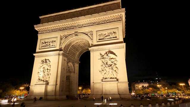 Arc de Triomphe standing brightly illuminated against a dark night sky