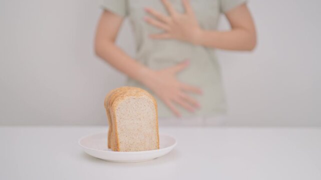 Gluten intolerance, Gluten free and celiac disease or Wheat allergy. woman with wheat bread and having abdominal pain after eat gluten. stomach ache, Nausea, Bloating, Gas, Diarrhea and Skin rash