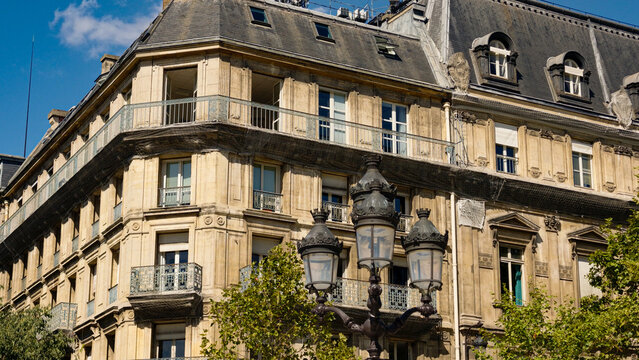 Parisian Haussmann building with balconies and a detailed antique street lamp