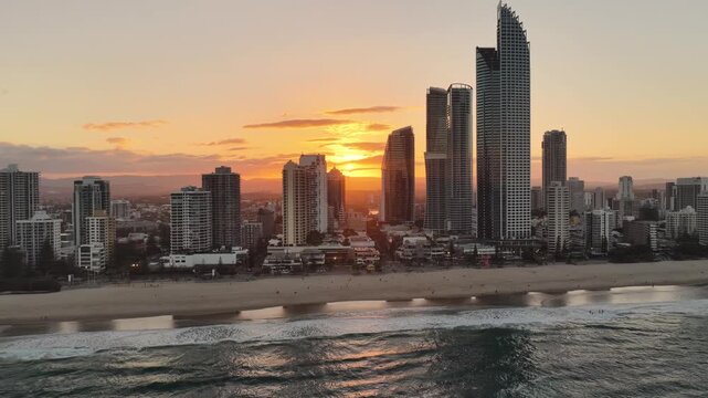 Aerial drone footage of the Gold Coast skyline at dusk with the surf in the foreground, Queensland Australia