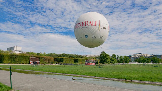 PARIS, FRANCE - SEPTEMBER 1, 2026 - Generali hot air balloon rising over the park with a duck swimming